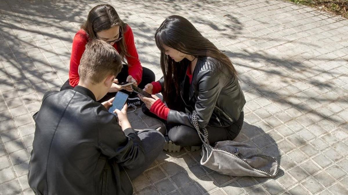 Tres adolescentes usando las redes sociales.