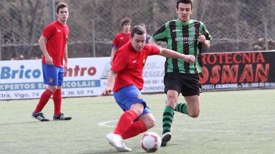 Un jugador del Ourense B golpea un balón ante un futbolista del Allariz. // Iñaki Osorio