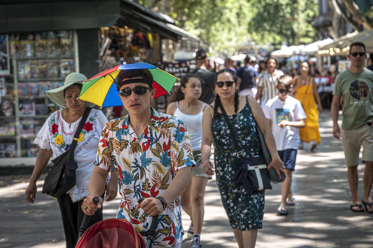 Ola de calor en Barcelona. turtistas refrescandose o resguardandose del calor por las ramblas.