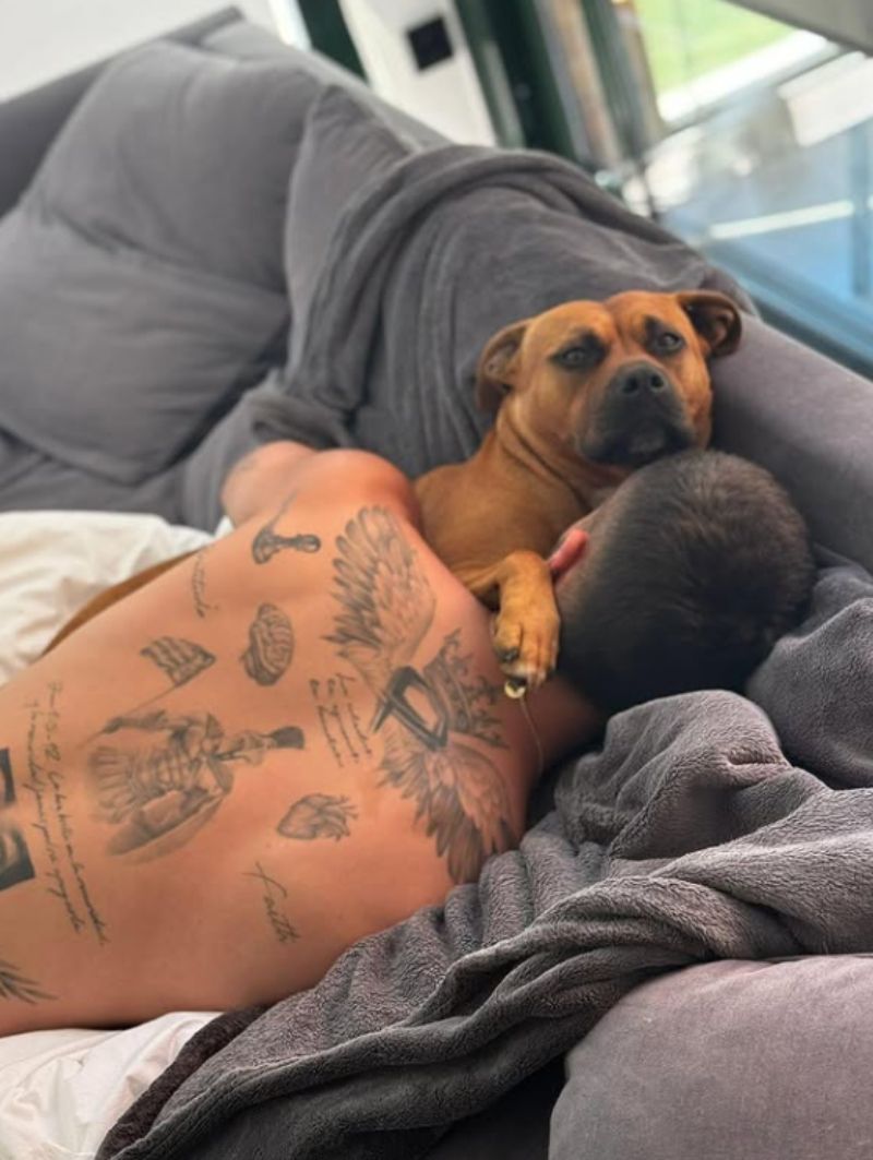 Ferran Torres y su perro, descansando en el sofá del salón de su casa