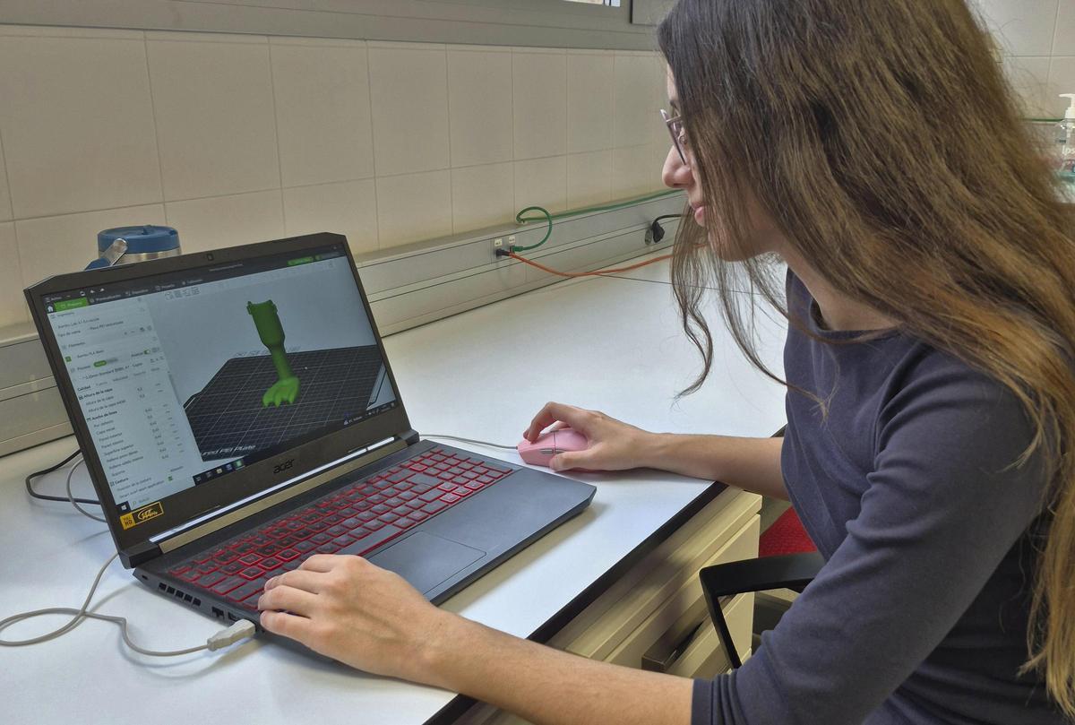 Ana Zamora observando en un ordenador los diseños de prótesis que imprimió en 3D para su TFG