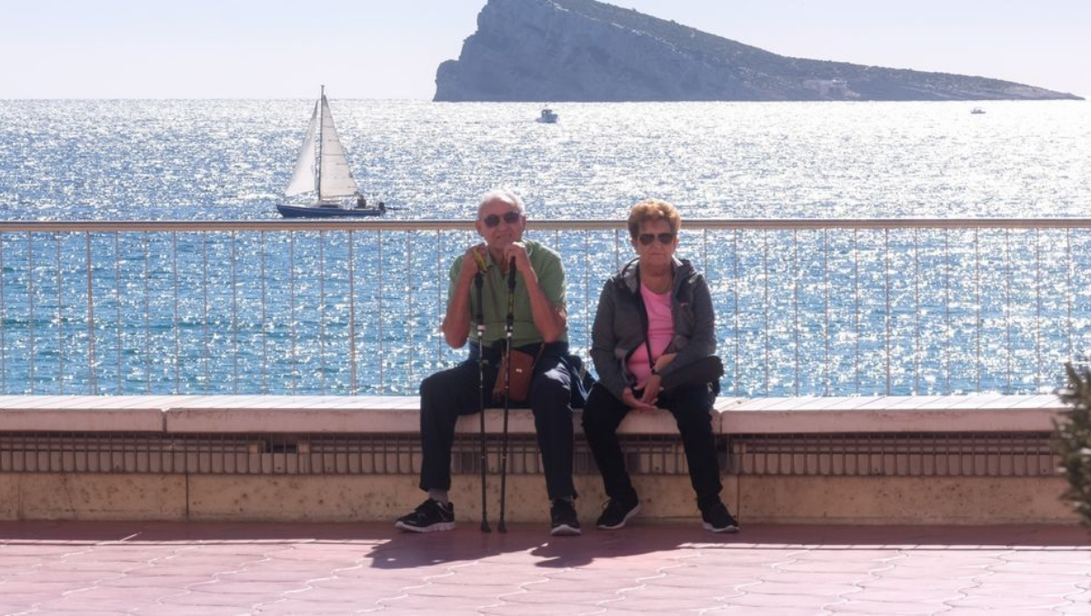 Una pareja de jubilados descansa en el paseo de Levante de Benidorm