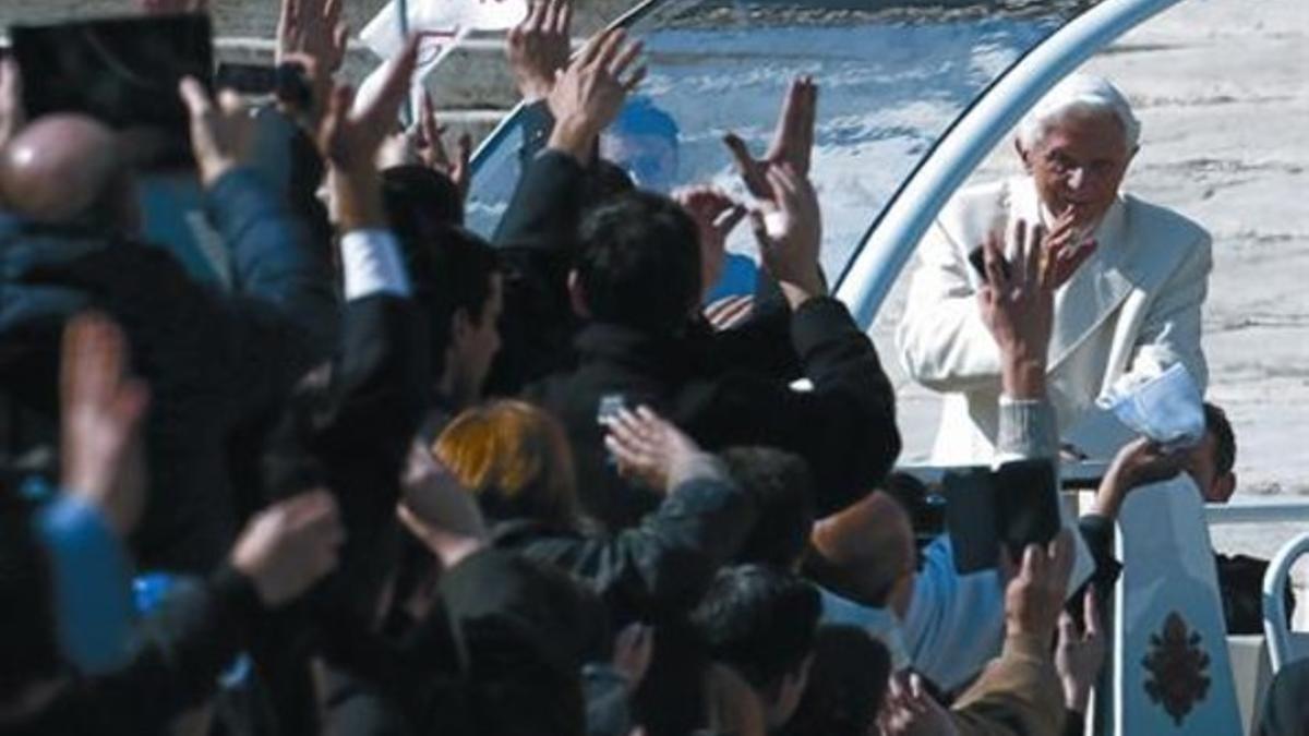 Benedicto XVI saluda desde el 'papamóvil' a los asistentes a su última audiencia, ayer.