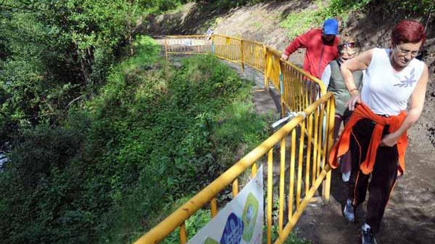 Usuarios del sendero pasan por una de las zonas más deterioradas del tramo que hoy se cierra.