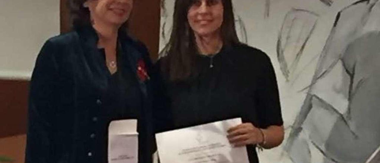 La asturiana (a la derecha) recibe el premio nacional de manos de la presidenta de la Sociedad Española de Psiquiatría Biológica, Ana González Pinto, el pasado viernes en Barcelona.