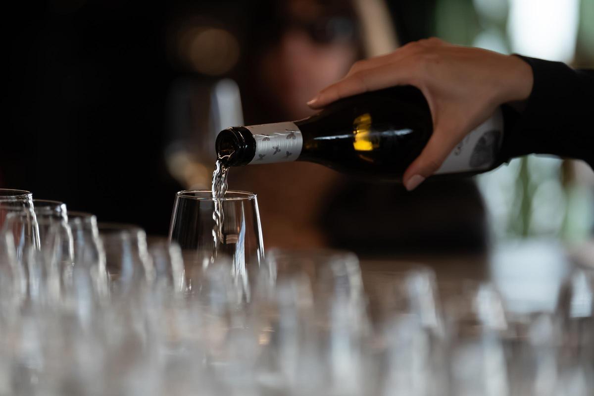 Un camarero sirve una copa de vino.