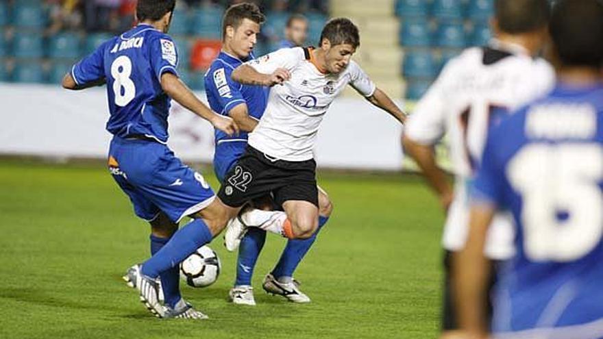 Dorca i Galan intenten robar la pilota al jugador del Salamanca Toti.