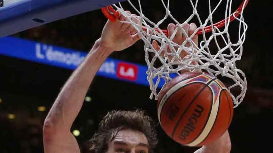 A la izquierda, Gasol machaca el aro francés; sobre estas líneas, el pívot se convierte en el centro de la celebración española. Fotos Efe