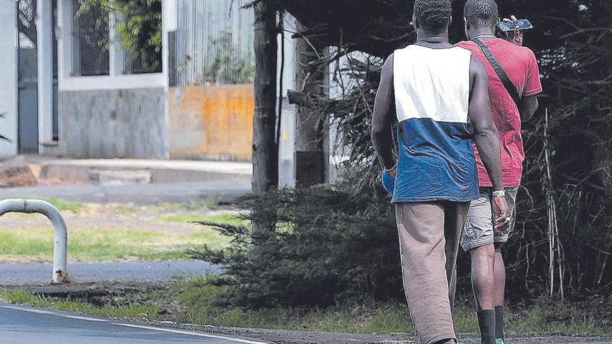 Dos jóvenes africanos regresan al exacuartelamiento de Artillería de La Laguna a la hora del almuerzo. | | MARÍA PISACA