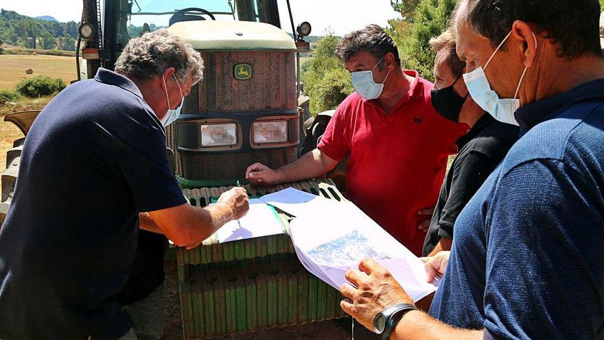 Veïns de Castellfollit mirant els plànols de la zona on es planteja el projecte del camp fotovoltaic de 90 ha