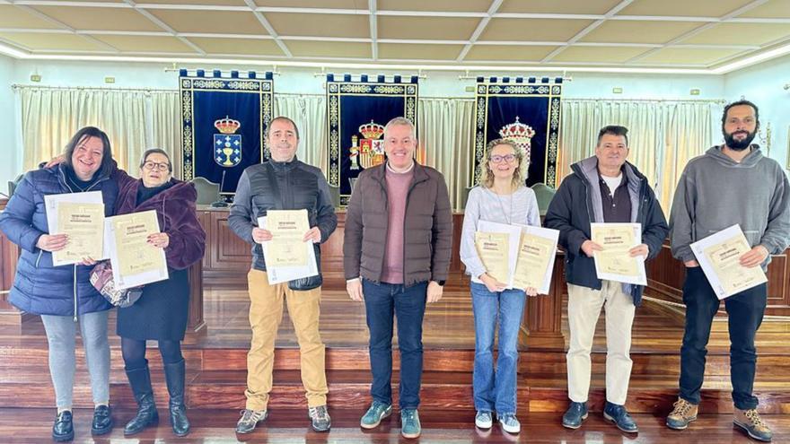 Los premiados en el sorteo de rifas recogiendo sus vales. | D.P.