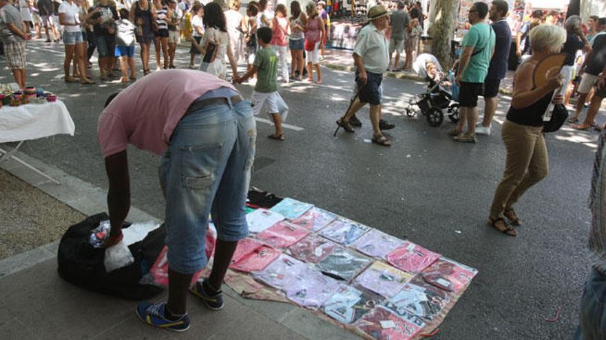 Un mantero se dispone a vender su mercancía.