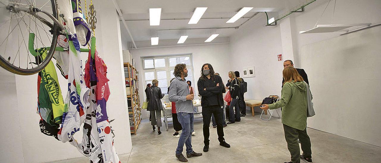 Pablo de Lillo, a la izquierda, en su estudio, conversa con algunos de los visitantes a la exposición. En primer término, una obra de David Martínez.