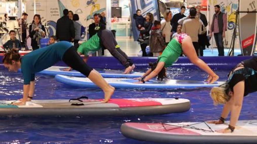 Una profesora de sup yoga imparte un taller en una piscina en IFA.