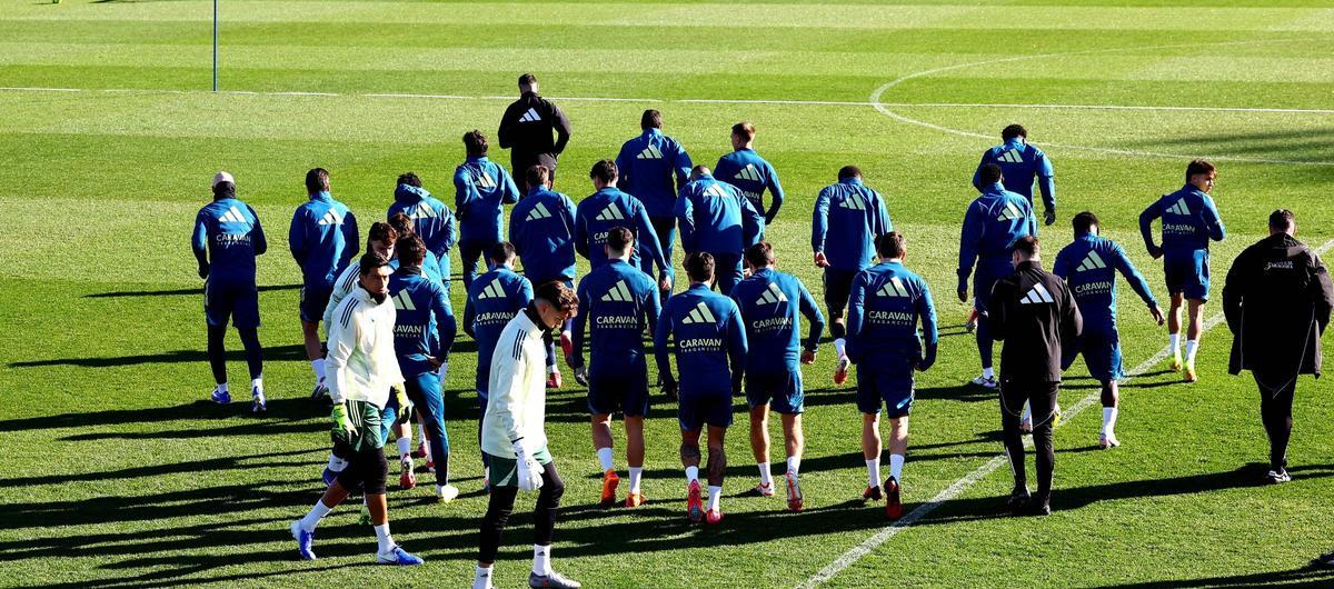 Los jugadores zaragocistas, de espaldas antes de empezar un entrenamiento.