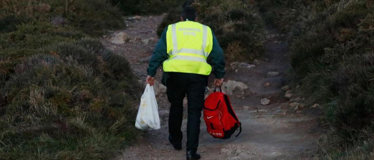 Un guardia civil inspecciona el borde de uno de los acantilados de Peñas, desde donde podría haberse precipitado al mar la persona cuyo cuerpo fue avistado flotando en el agua. | Mara Villamuza