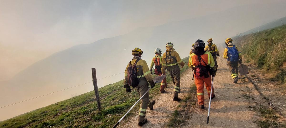 Los bomberos se organizan para tratar de extinguir el incendio en Tineo.