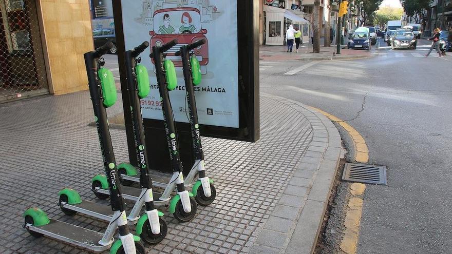 Patinetes eléctricos apargados en la acera.