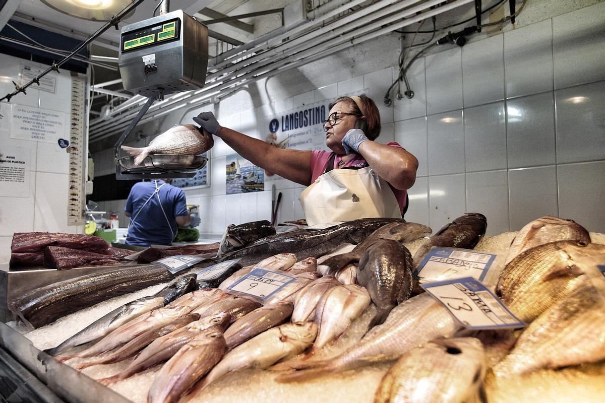 Una mujer pesa un ejemplar en la pescadería del Mercado La Recova, en Santa Cruz de Tenerife.