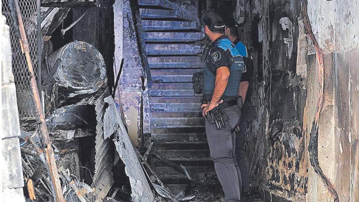 Dos policias en el interior del edificio incendiado en Vigo
