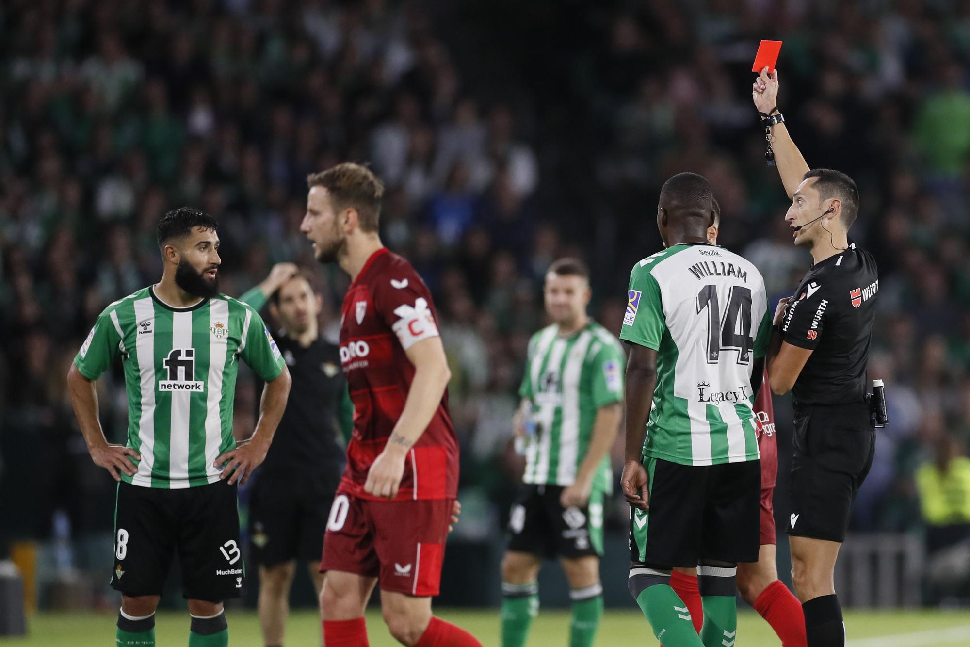 Sánchez Martínez muestra una de las tres rojas que enseñó en el Betis-Sevilla.