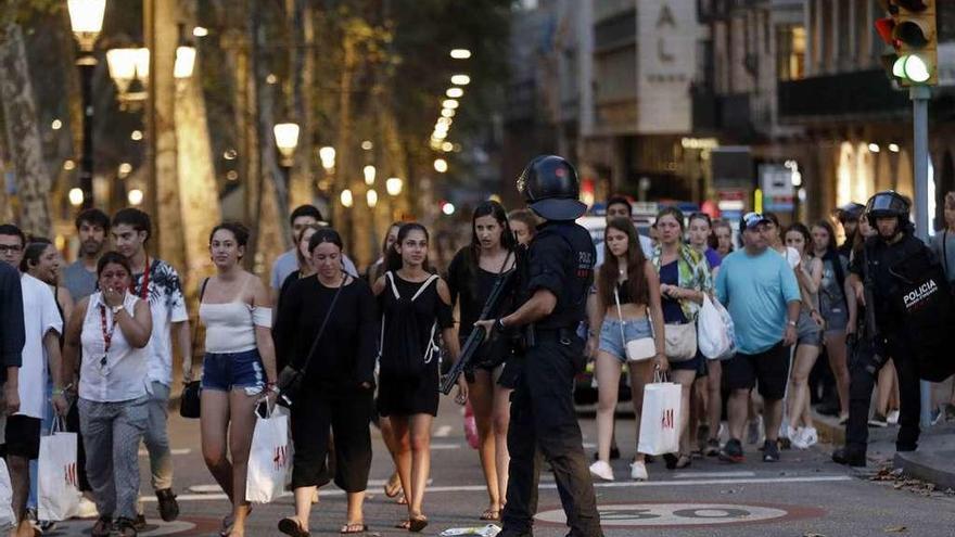 Personas refugiadas en los comercios de la zona de las Ramblas comienzan a salir horas después del atentado. // Reuters