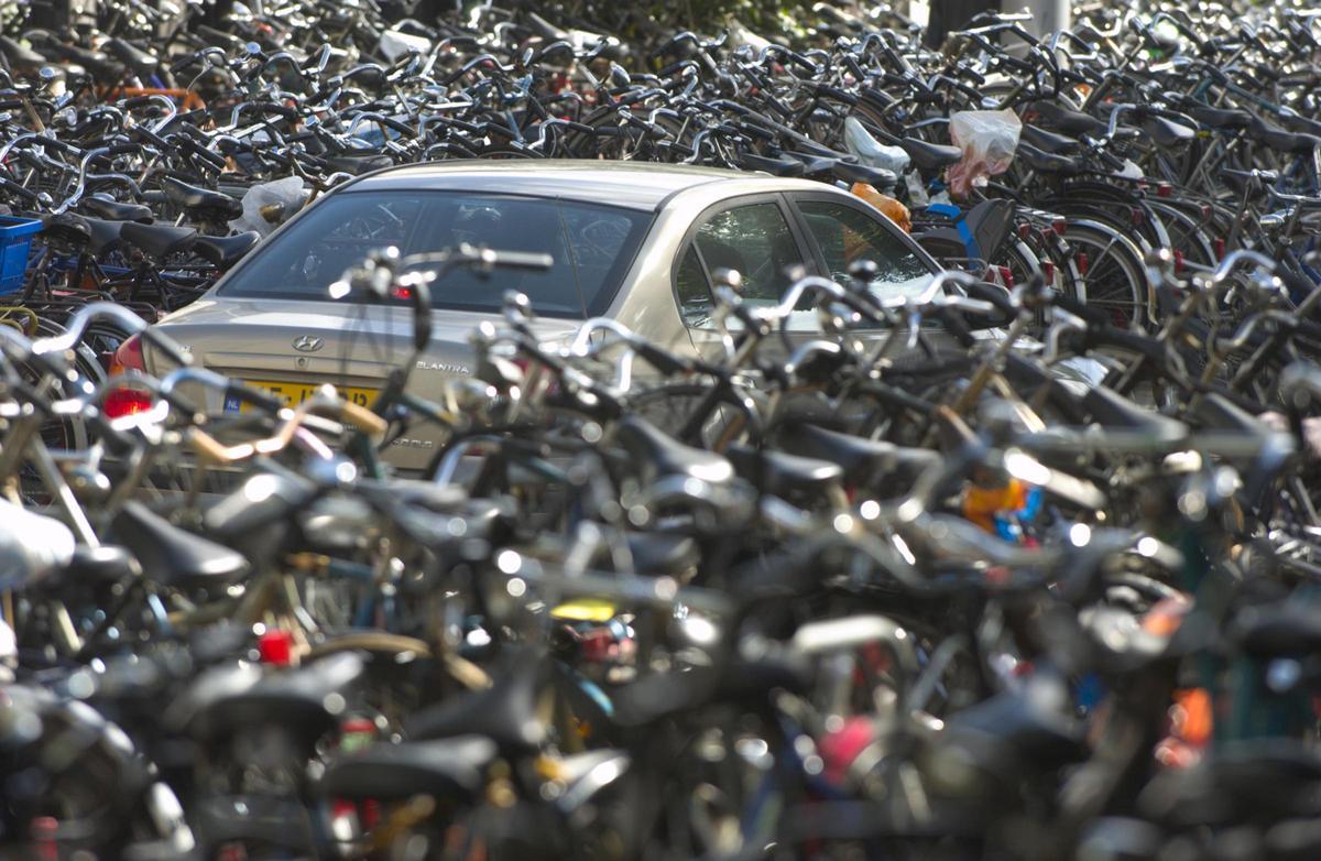 Un coche, casi sepultado por centenares de bicicleta, en la estación central de trenes de Amsterdam