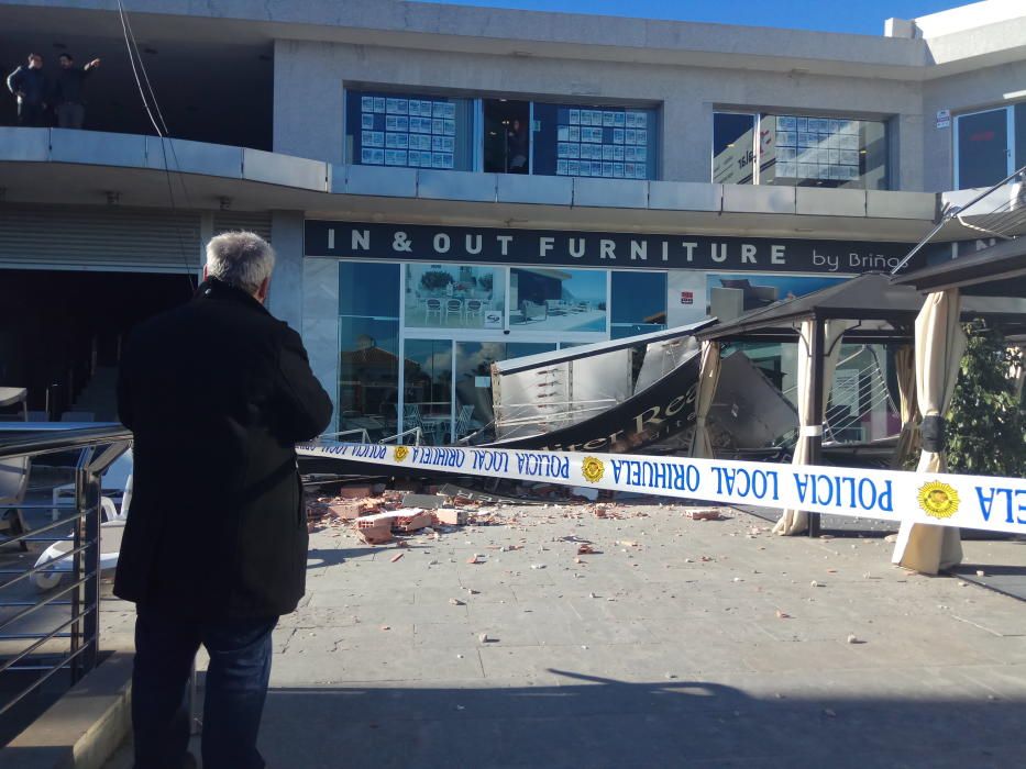 El viento derriba un cartel de grandes dimensiones sobre la terraza de un centro comercial en Orihuela Costa sin causar víctimas