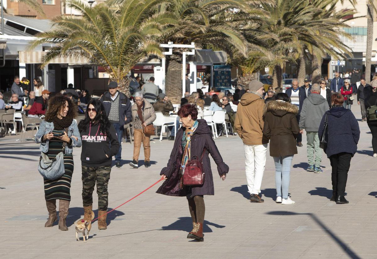 Personas paseando junto a a playa del Port de Sagunt.