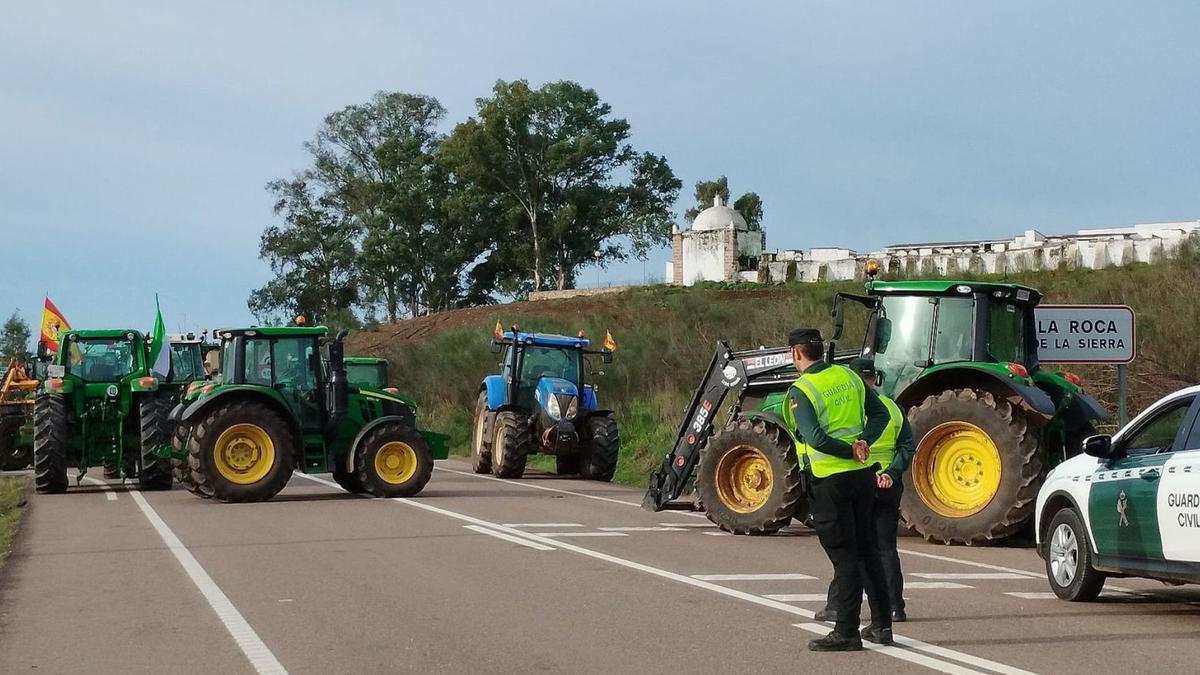 Los agricultores han cortado con sus tractores la carretera que une Cáceres y Badajoz a la altura de La Roca de la Sierra.
