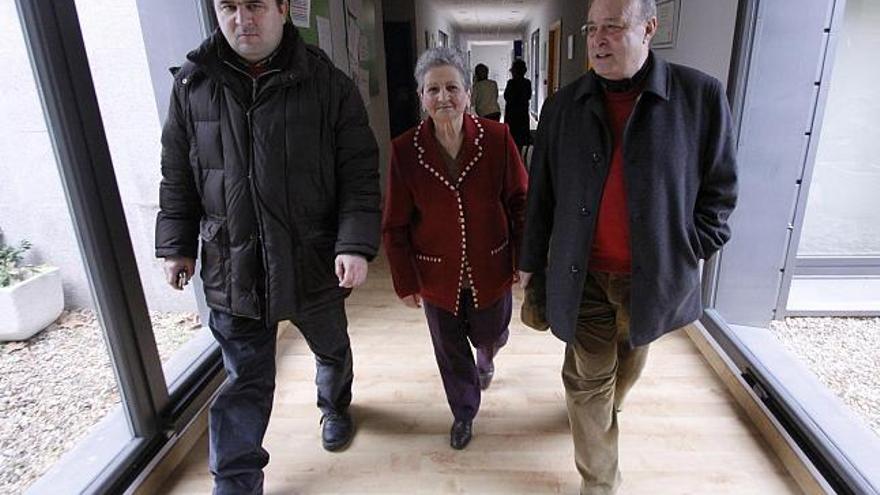 Antonio, Aurora y Justo recorren el pasillo del centro «Ciudad Jardín», en el que atienden a sus familiares enfermos de alzheimer cada día.