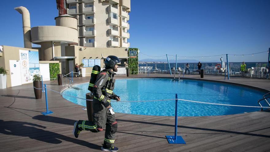 Uno de los bomberos participantes atraviesa la piscina del hotel fuengiroleño.