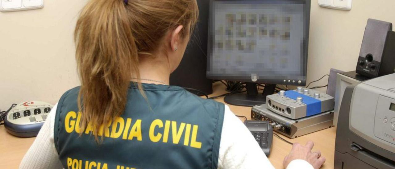 Una agente de la Guardia Civil revisa un ordenador.  | // EFE