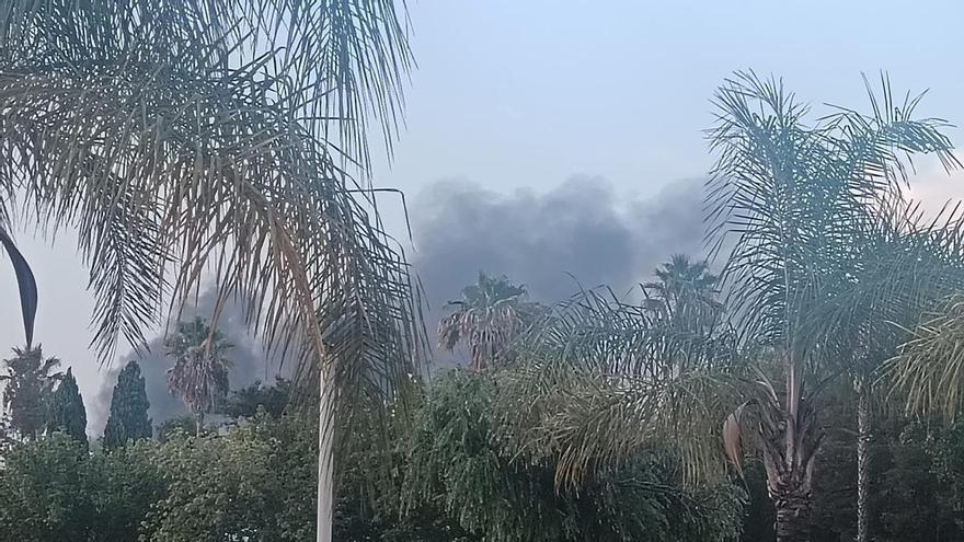 Una gran humareda negra se eleva en Huelva tras arder dos máquinas en una nave industrial