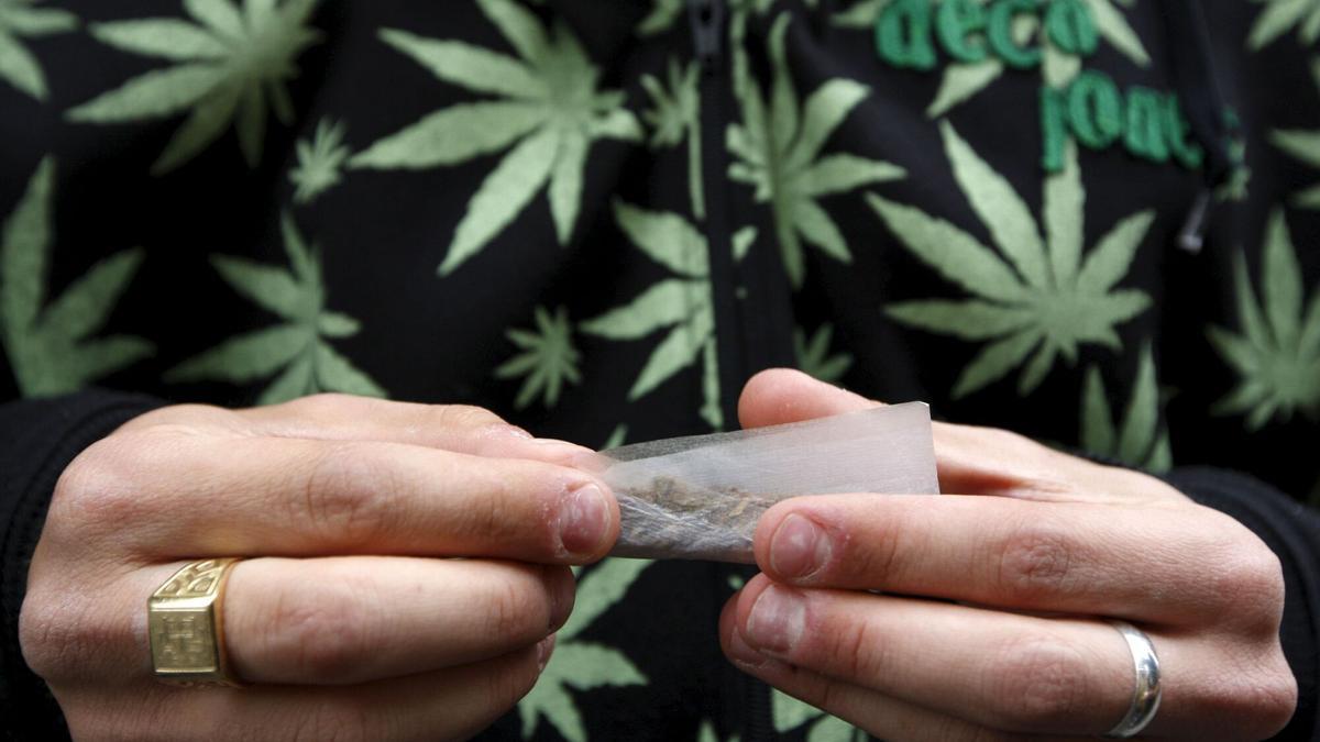 Un consumidor de marihuana liándose un porro.