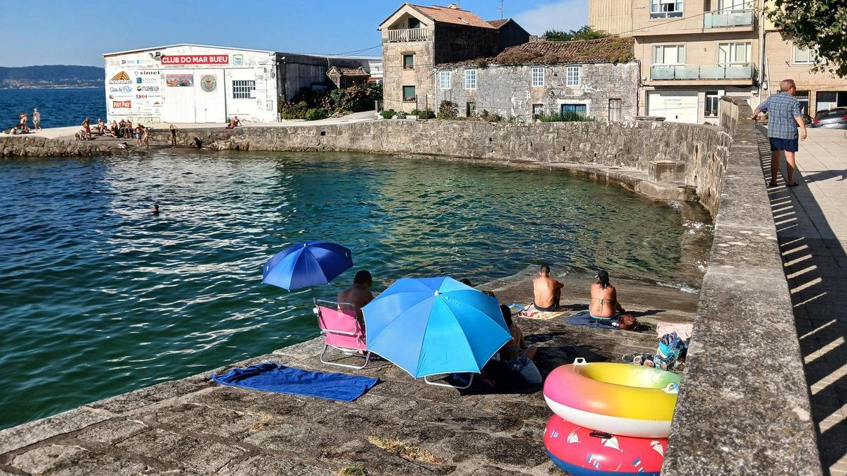La vivienda antigua objeto de litigio situada en Pescadoira (en el centro de la imagen), este sábado, en Bueu.