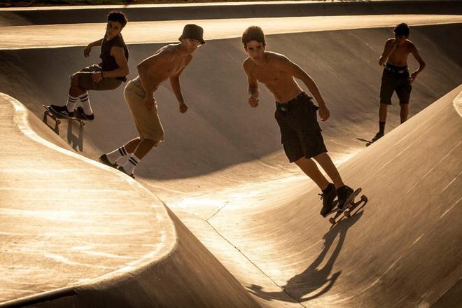 Jóvenes practican skate durante el atardecer, cerca de la zona de la playa de la Mar Bella de Barcelona.