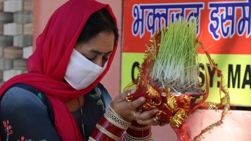 Una persona hindú reza antes de soltar los cuencos con &quot;Saakh&quot; fuera de un templo cerrado en Jammu.