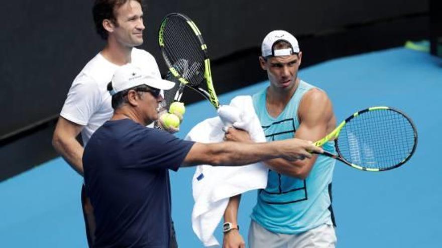 Rafa Nadal, parlant ahir a Melbourne amb Carles Moyà i Toni Nadal, el seus entrenadors.