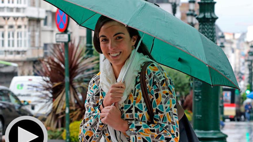 Una joven se protege de la lluvia en el centro de Vigo.//M. G. Brea