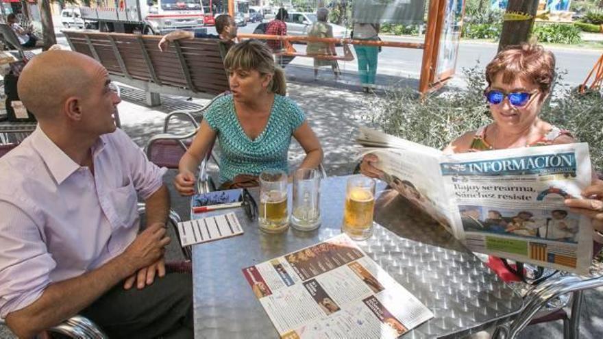 En Alcoy, la perplejidad y la oposición a más comicios marcaron las conversaciones. A la derecha, dos jóvenes miran el resultado en Alicante.