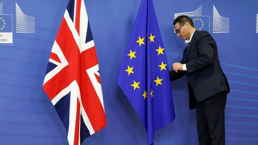 Un funcionario europeo, con las banderas británica y de la UE.