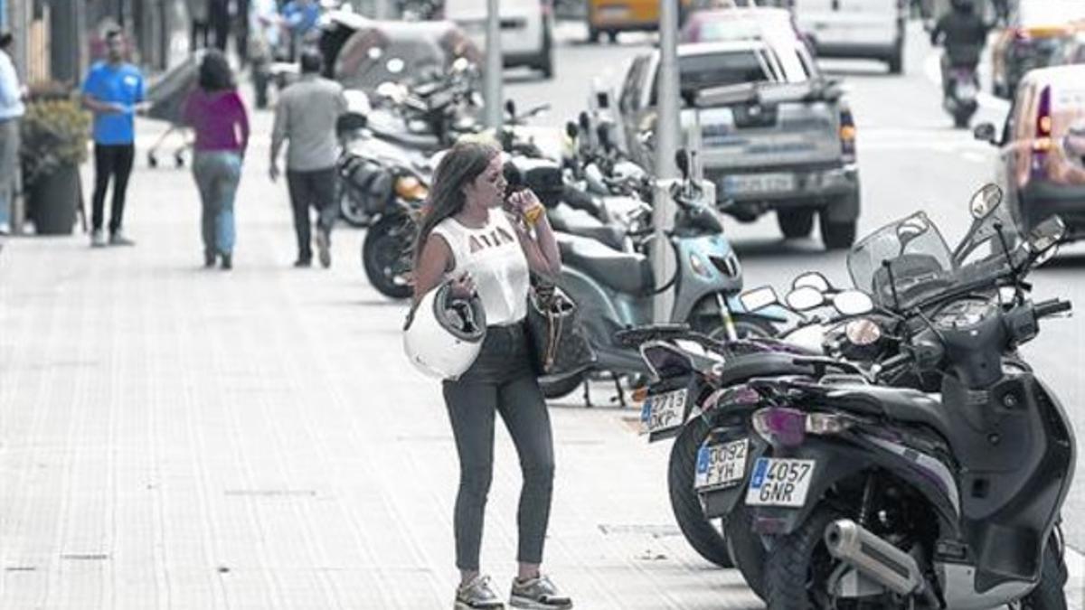 Semibatería 8 Una joven se dispone a coger su moto, aparcada sobre la nueva acera de Balmes, el lunes.