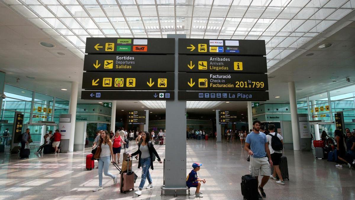 Un grupo de personas transitan en el Aeropuerto de Barcelona.
