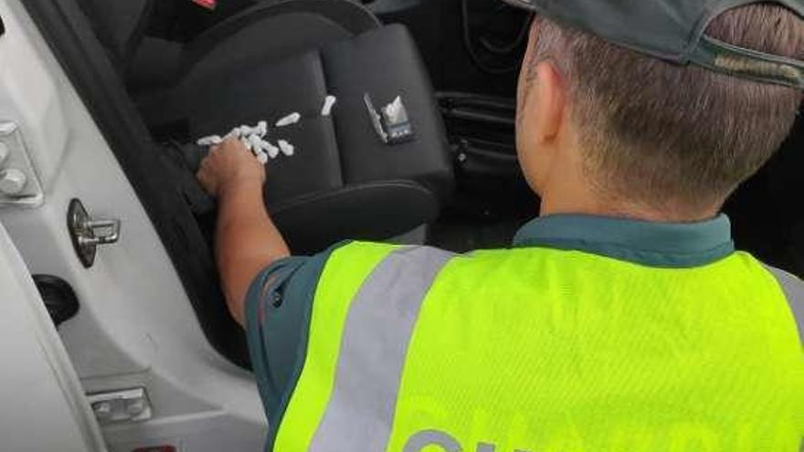 Un agente con la papelinas encontradas en el coche. // Guardia Civil