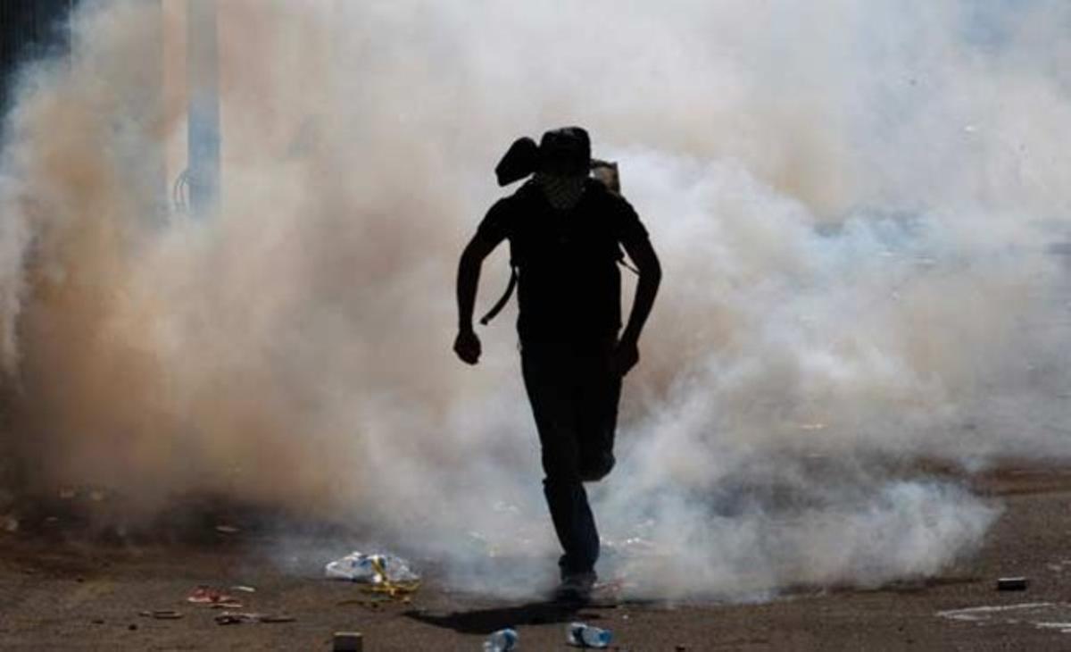 Un manifestant fuig d’un núvol de gas lacrimogen llançat pels antiavalots israelians a la localitat israeliana d’Umm al-Fahm, de majoria resident àrab. La policia va dispersar 200 persones, després dels altercats que van tenir lloc al pas d’una marxa de l’extrema dreta jueva.