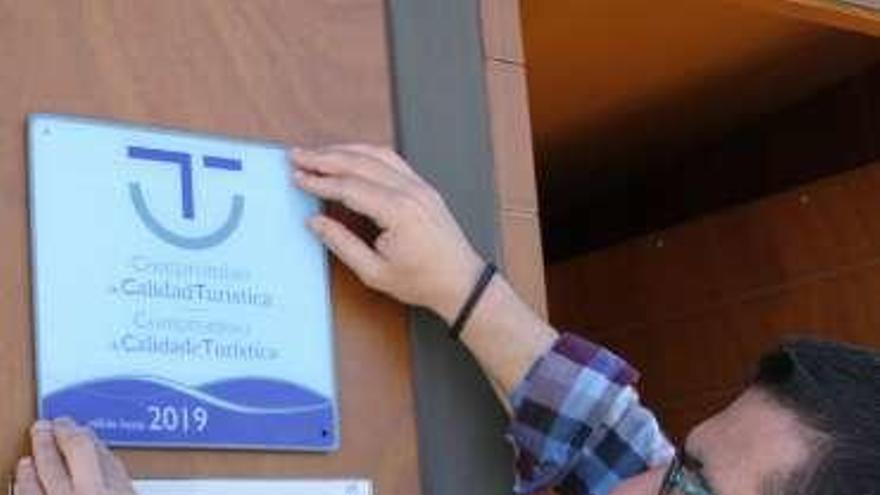 Vilariño coloca la placa en la oficina de turismo lalinense.
