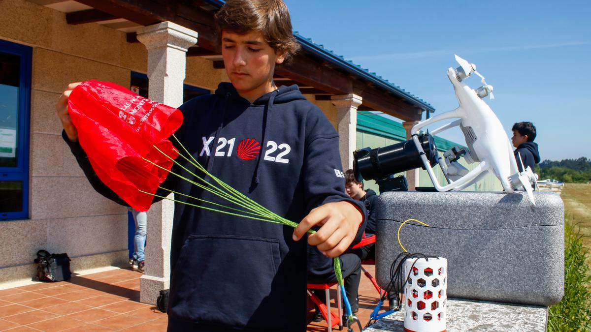 Uno de los alumnos mostrando el paracaídas que atenuó el descenso del satélite.