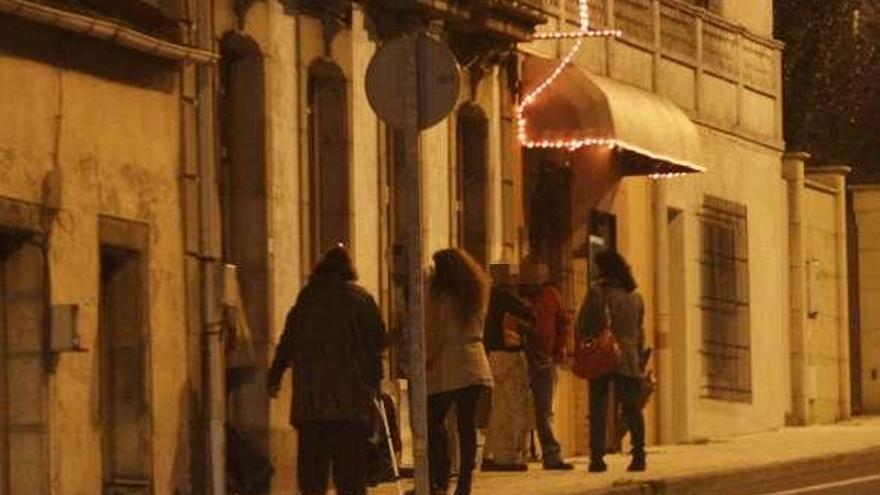 Gente en la puerta de la casa ocupada, en Rubiáns.  // J. L. Oubiña