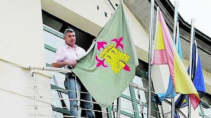 Marcelino Martínez sujeta la bandera coyana en el balcón consistorial.